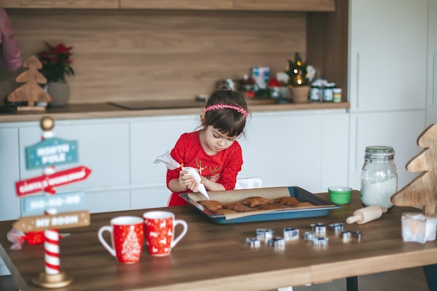 Bambina che decora i biscotti di Natale