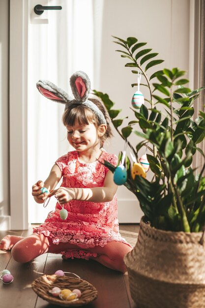 Bambina che decora una pianta per le vacanze di Pasqua