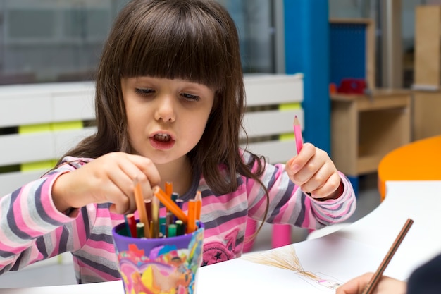 Bambina che disegna nella stanza dei giochi