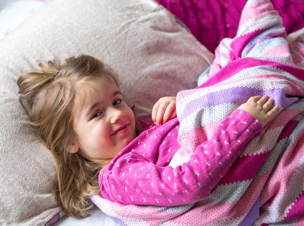 bambina che dorme in un letto rosa