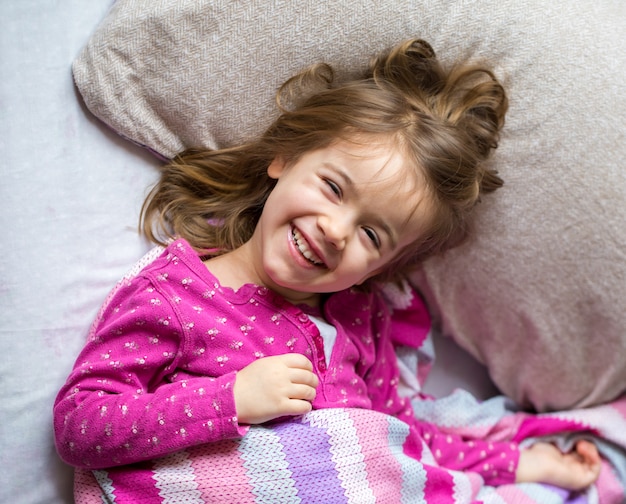 bambina che dorme in un letto rosa