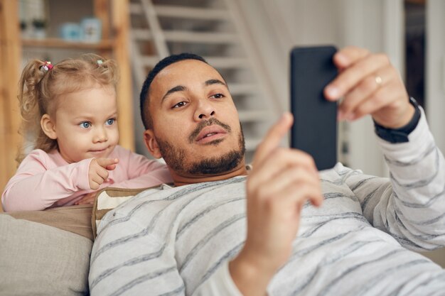 Bambina che esamina papà Smartphone