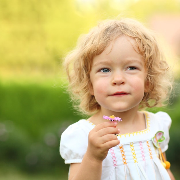 Bambina che esprime un desiderio con il fiore di primavera