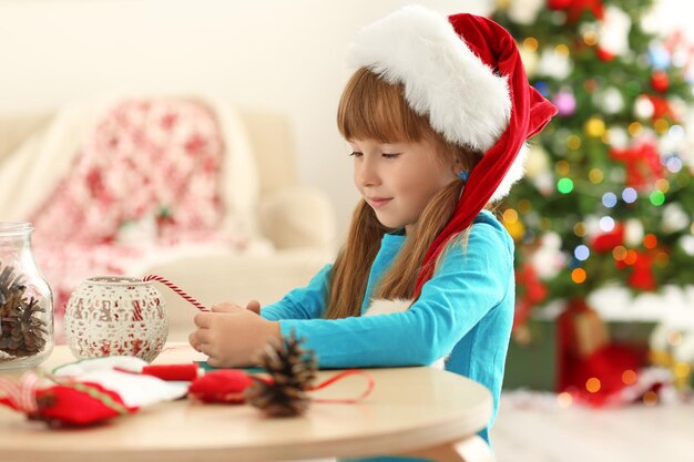 Bambina che fa decorazioni natalizie a tavola