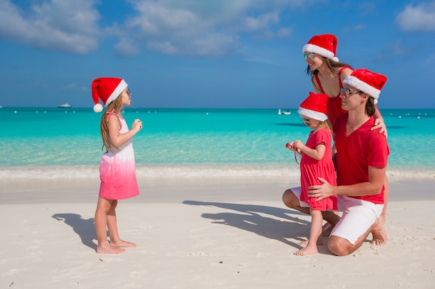 Bambina che fa foto sul telefono della sua famiglia alla spiaggia