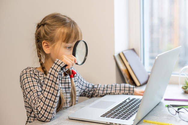 Bambina che fa i compiti a casa e usa un laptop