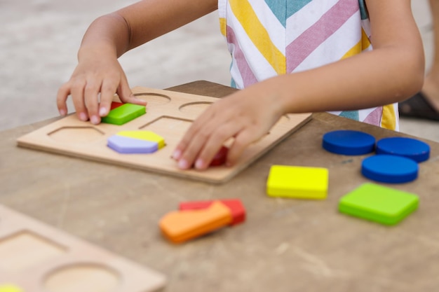 Bambina che fa puzzle di legno colorato