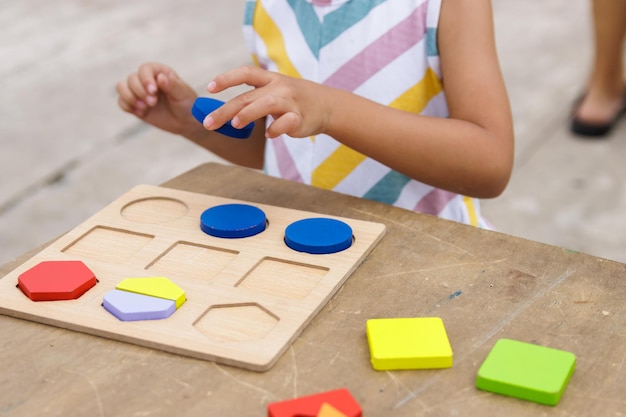 Bambina che fa puzzle di legno colorato