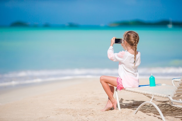 Bambina che fa video o foto con dalla sua macchina fotografica che si siede sul lettino