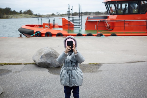 Bambina che fa video o foto con il telefono cellulare