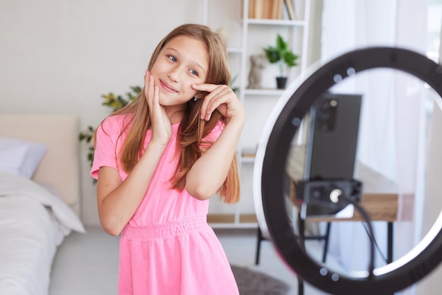 Bambina che fa video per blog tramite telefono a casa