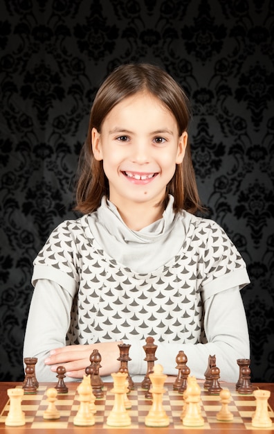 bambina che gioca a scacchi sul muro d'epoca