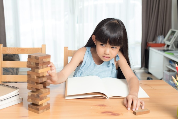 Bambina che gioca blocchi di legno impilare il gioco, l'apprendimento e il concetto di sviluppo