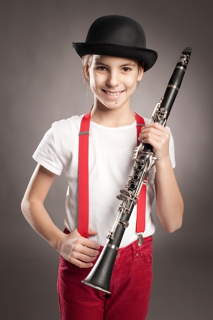 Bambina che gioca clarinetto su gray