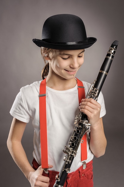 Bambina che gioca clarinetto su gray