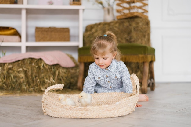 Bambina che gioca con i polli il giorno di Pasqua