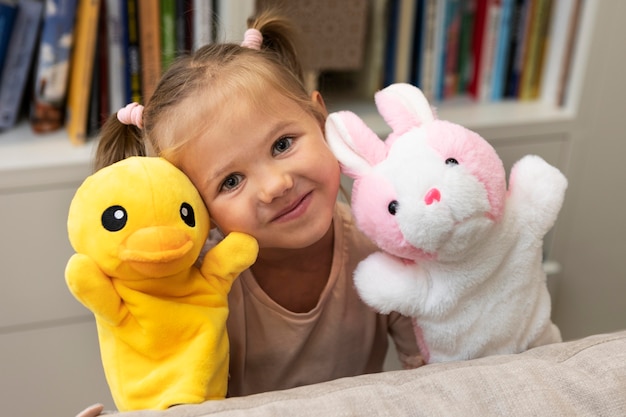 Bambina che gioca con i suoi burattini a casa