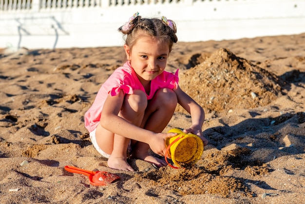 bambina che gioca con la sabbia sulla spiaggia