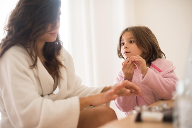 Bambina che gioca con sua madre gioielli e trucco