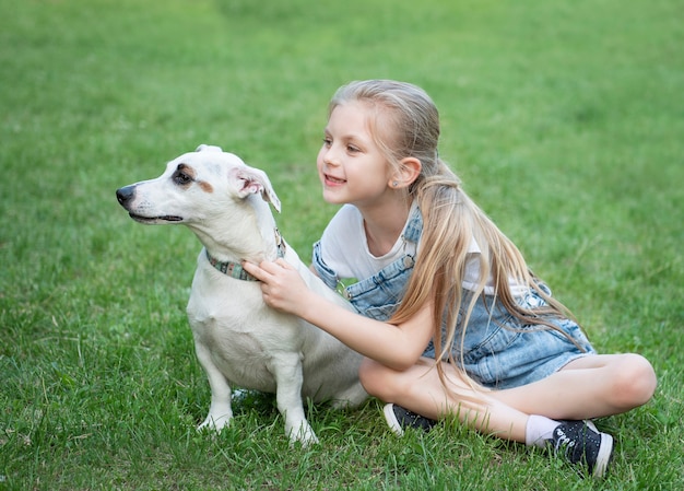 Bambina che gioca con un cane di razza Jack Russell Terrier