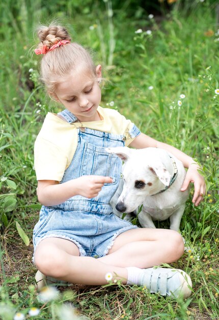 Bambina che gioca con un cane di razza Jack Russell Terrier