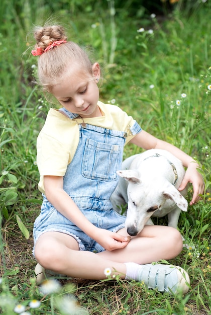 Bambina che gioca con un cane di razza Jack Russell Terrier