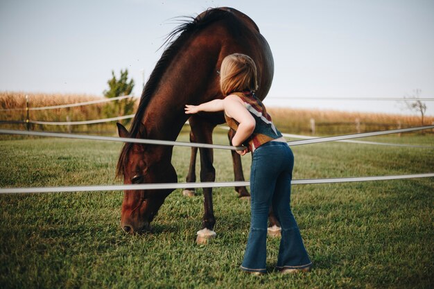 Bambina che gioca con un cavallo