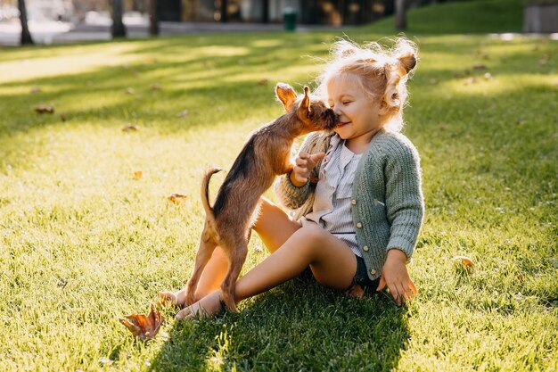 Bambina che gioca con un cucciolo all'aperto