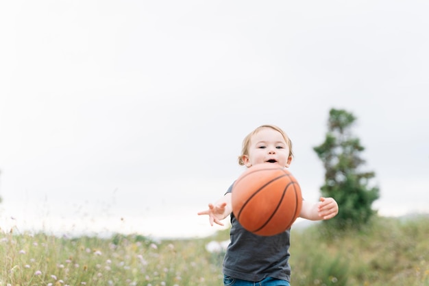 Bambina che gioca con una palla all'aperto