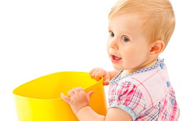 Bambina che gioca con una scatola di plastica gialla