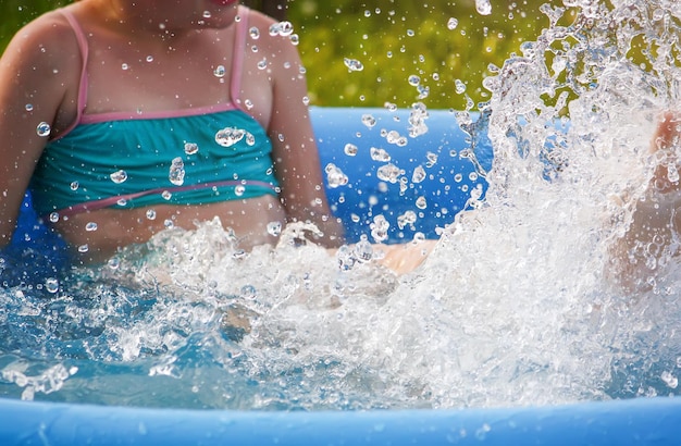 Bambina che gioca in piscina all'aperto in estate