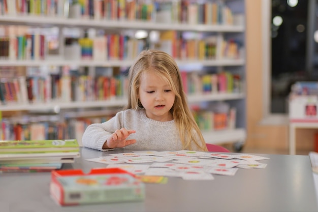 Bambina che gioca in una biblioteca