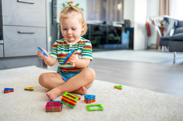 Bambina che gioca kit blocchi di plastica magneti colorati a casa il bambino che gioca a giochi educativi e...