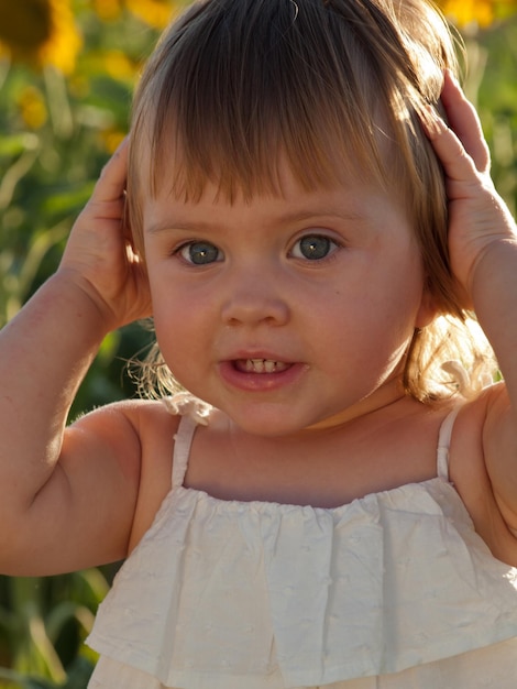 Bambina che gioca nel campo di girasoli.