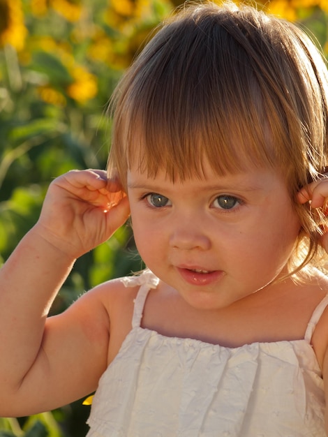 Bambina che gioca nel campo di girasoli.