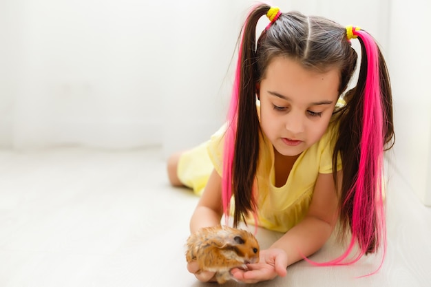 Bambina che guarda da vicino il suo criceto