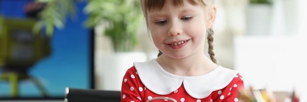 Bambina che impara a capire il tempo e gioca con l'orologio vintage rosso