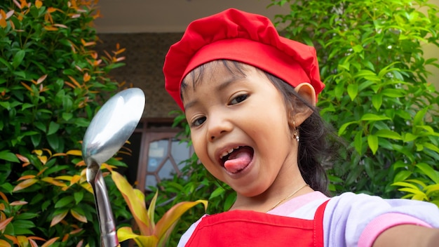 Bambina che indossa abiti da cucina rossi