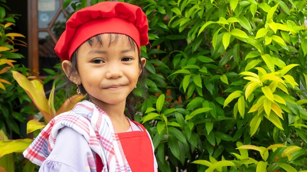 Bambina che indossa abiti da cucina rossi