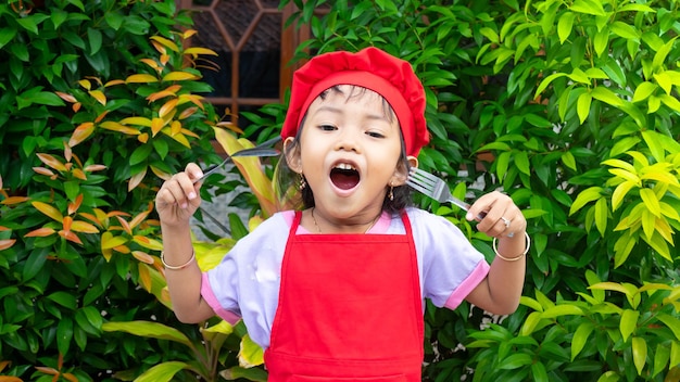 Bambina che indossa abiti da cucina rossi