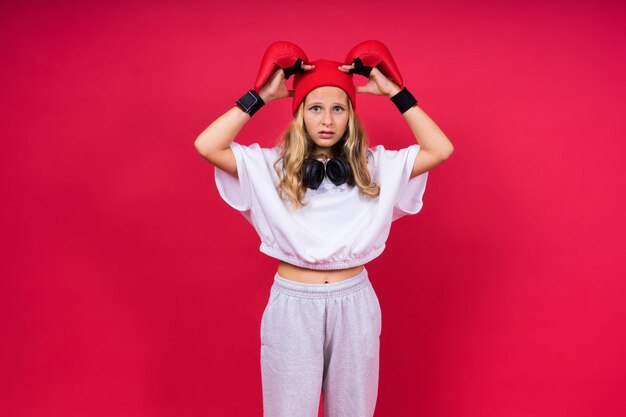 Bambina che indossa guantoni da boxe rossi girato in studio concetto di sport