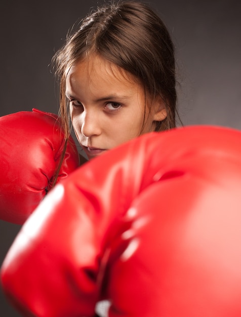 bambina che indossa guantoni da boxe rossi