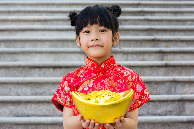 Bambina che indossa il vestito tradizionale cinese sul nuovo anno cinese