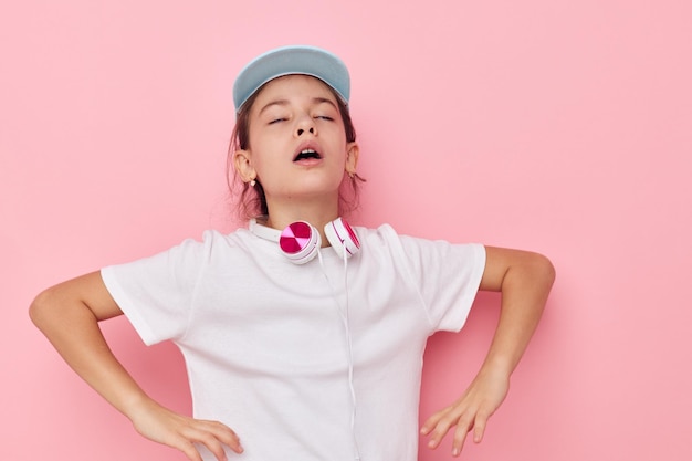 Bambina che indossa le cuffie in posa emozioni sfondo isolato