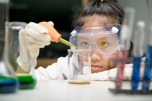 Bambina che indossa occhiali di protezione safty facendo esperimento