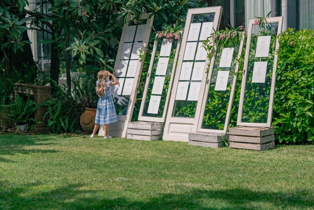 Bambina che legge le liste degli ospiti in giardino