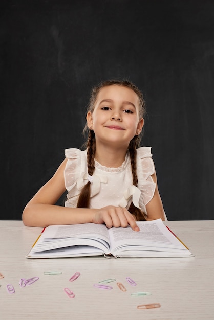 Bambina che legge un libro in classe