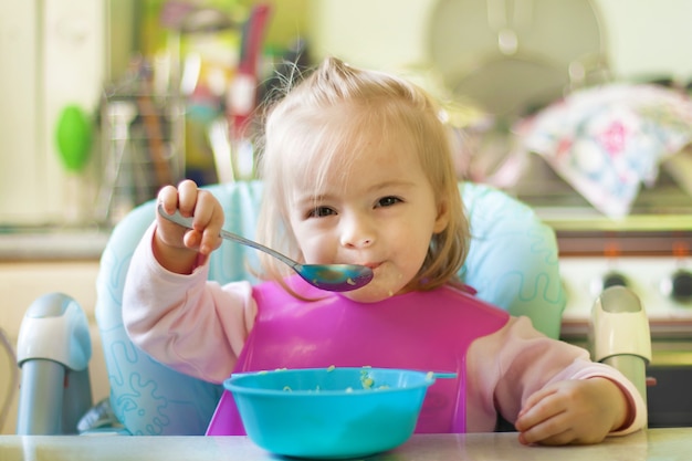 Bambina che mangia in cucina