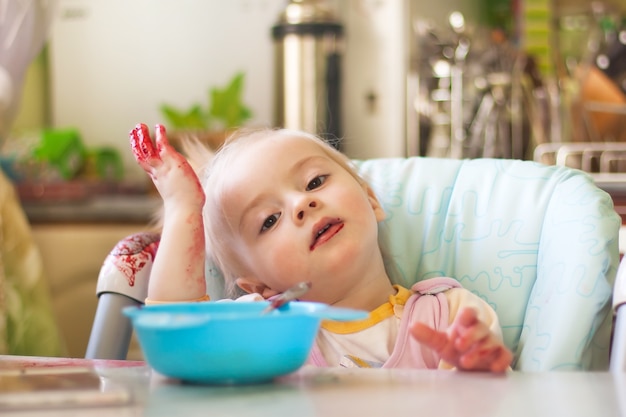 Bambina che mangia in cucina