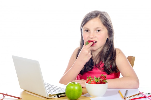 Bambina che mangia una fragola